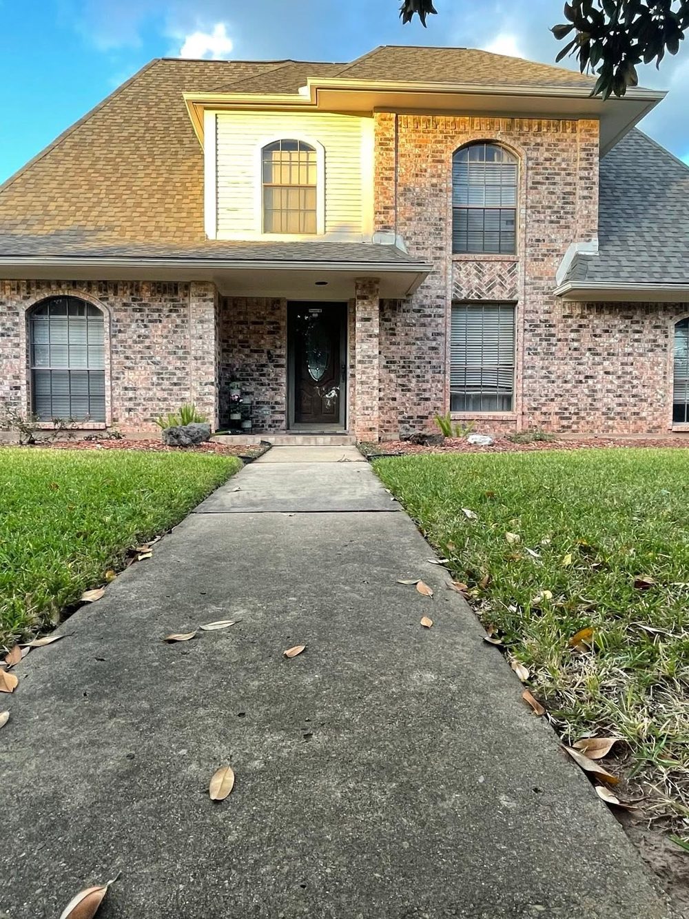 A new shingle roof and gutters on a red barn by HTX Roofing & General Construction